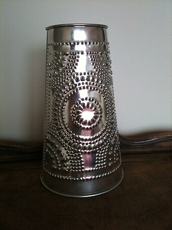 A 21st-century reproduction barn lantern made of punched tin.