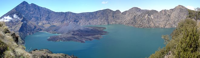 Vue panoramique de l'intérieur de la caldeira Segara Anak avec son lac de cratère et le Barujari, son cône actif, dominés par le mont Rinjani.