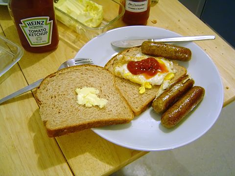 A sausage sandwich with egg and ketchup