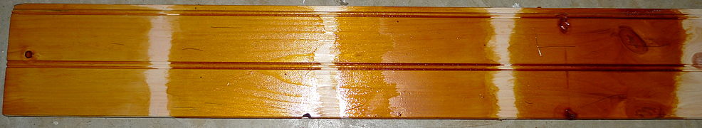 "Quick and dirty" example of a pine board coated with 1–5 coats of Dewaxed Dark shellac (a darker version of traditional orange shellac)