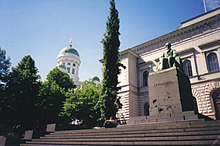 The Bank of Finland, Helsinki, with the statue of Johan Vilhelm Snellman by sculptor Emil Wikstrom in front Snellman Statue Helsinki.jpg