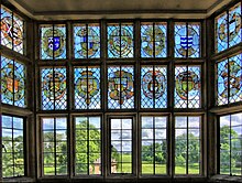 The window of the Great Chamber depicts the arms of families connected to the Phelips family by marriage Stained glass window, overlooking gardens of Montacute House (4675709559).jpg