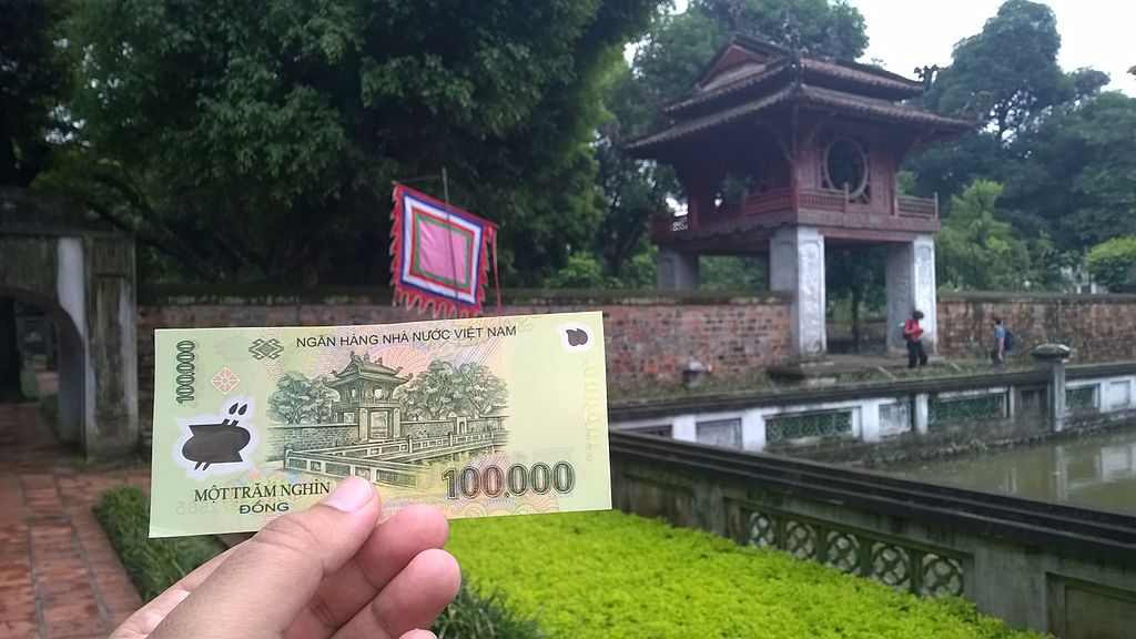 Temple of Literature in Hanoi with a 100.000 Dong banknote 2015