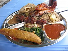 Traditional Tanzanian food consisting of pilau kuku (seasoned rice with chicken), mishkaki (grilled meat), ndizi (plantain), maharage (beans), mboga (vegetables), chapati (flatbread) and pili pili (hot sauce) Traditional Tanzanian food - pilau kuku, mishkaki, ndizi, &c..JPG