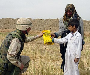 US Navy 030412-A-0000C-001 U.S. Army Lt. Col. Randy Stagner gives two Iraqi children a Humanitarian Daily Ration meal near the city of Najaf.jpg