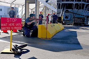 US Navy 120126-N-ET019-654 Sailors assigned to the submarine tender USS Emory S. Land (AS 39) cover the pier during an anti-terrorism force protect.jpg