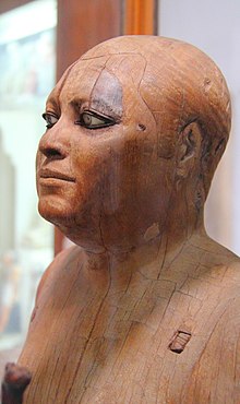 Wooden statue of the scribe Kaaper, 4th or 5th dynasty of the Old Kingdom, from Saqqara, c. 2500 BC Agyptisches Museum Kairo 2016-03-29 Ka-aper 01.jpg