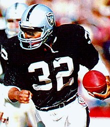 Allen playing for the Raiders in 1984 where he rushed for 1,168 yards, scored 18 touchdowns and led the Raiders to their third consecutive playoff appearance. 1985 Police Raiders-Rams - 01 Marcus Allen (crop).jpg
