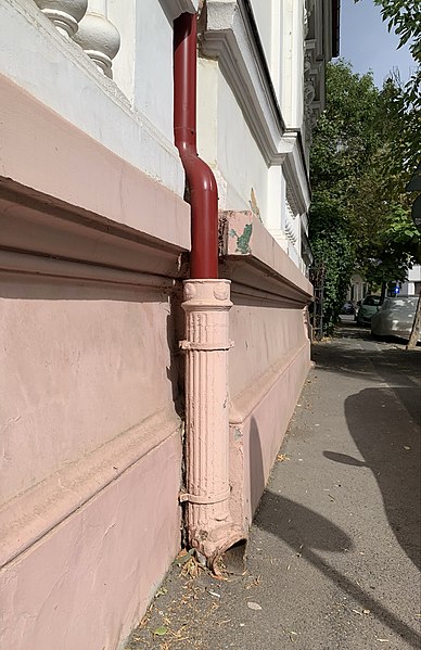 File:39 Strada Popa Soare (01). Late 19th century-early 20th century original cast iron pipe in the lower part of the picture, and contemporary red pipe in the upper part.jpg
