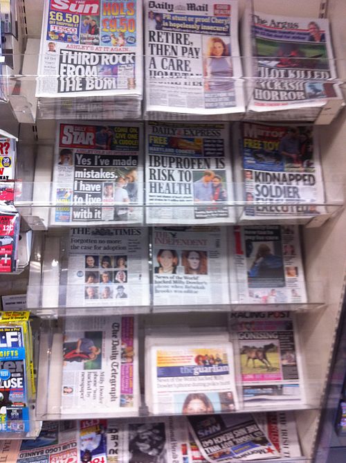 Display rack of British newspapers during the midst of the News International phone hacking scandal (5 July 2011). Many of the newspapers in the rack 