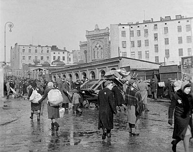 Ruch uliczny w getcie, widoczna Synagoga Alte Szil.