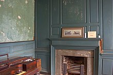 Simple architrave framing with a plain frieze and shelf above on the mantle. The off-center position of the fireplace is shown with the different widths of the side panels. Eppington Plantation Main Hall.jpg