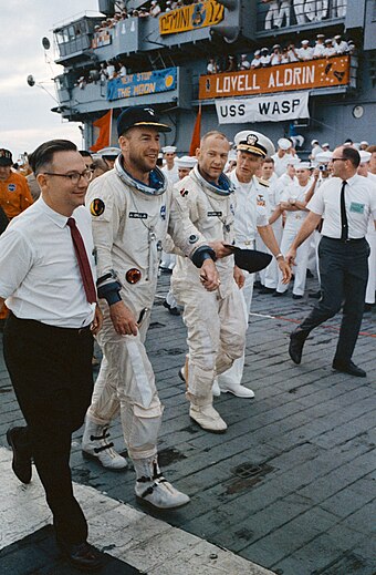 Lovell (second from left) and Buzz Aldrin (third from left) arrive aboard the recovery vessel, the aircraft carrier USS Wasp, after the Gemini 12 flight
