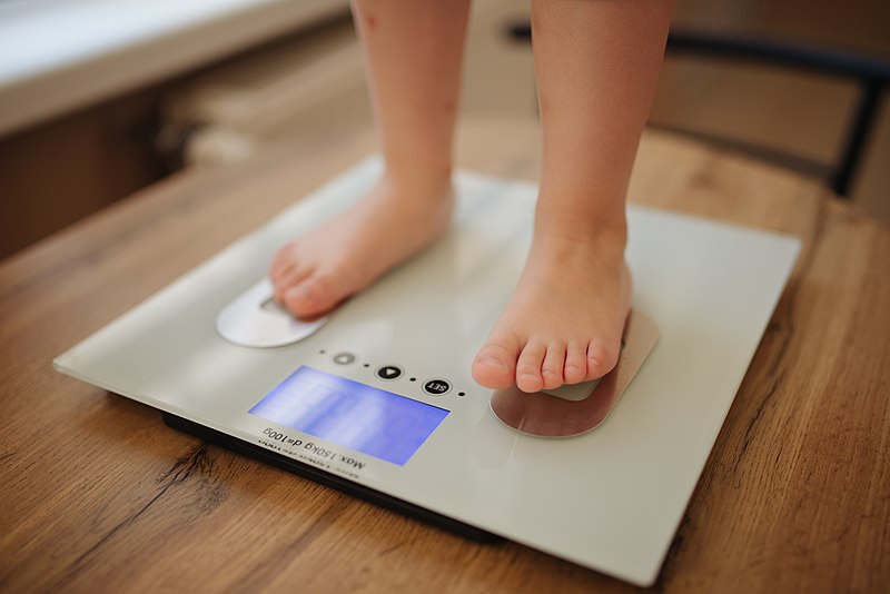 File:Girl stands and weighs himself on white modern electronic smart scale - 51258015258.jpg