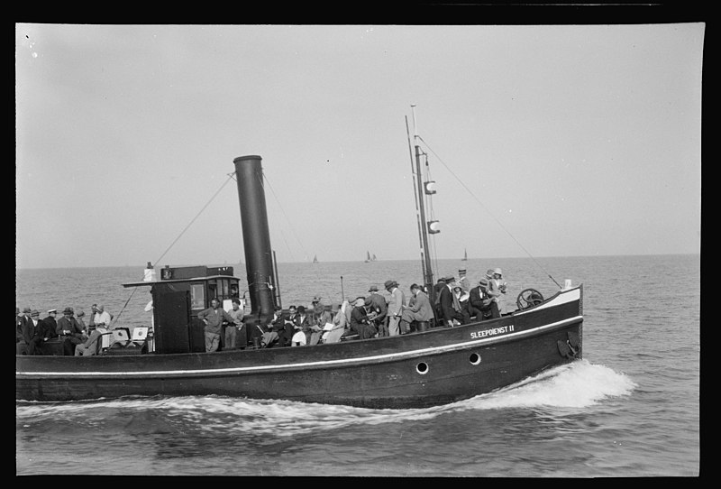 File:Het marinesleepbootje Sleepdienst II passeert vol gasten aan dek waarvan velen met een vel papier. O - RAA003013001 - RAA DenHelder.jpg