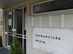 Kaukametsän opiston pääovi. Ulkoseinässä lukee Kaukametsän opisto