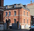 Residential house, office building, factory building, boiler and machine house with chimney, two outbuildings, courtyard entrance and courtyard paving of a former factory