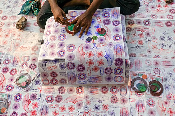 A street vendor in Vasco da Gama Square in Fort Kochi, India, demonstrates the spirographs he is trying to sell.