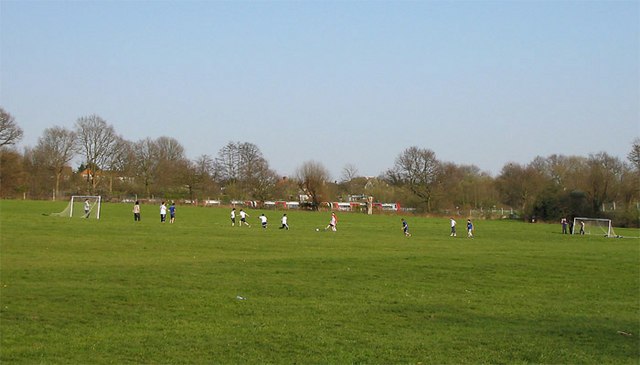 A Sunday football match in progress at Brook Farm open space.