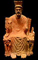 El déu Baal representat com un home gran en un tron entre dues esfinxs.