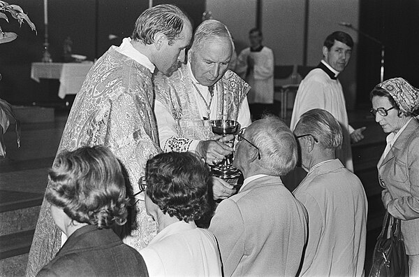 Veldhoven, Archbishop Lefebvre giving Communion assisted by Father Franz Schmidberger