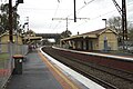 North-east bound view from Platform 2 looking at station buildings and pedestrian footbridge, May 2014