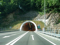 Straßentunnelportal mit Wechselverkehrszeichen über der Tunneleinfahrt