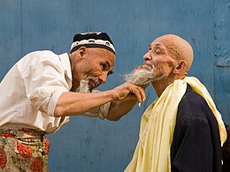 Uyghur Barber in Kashgar. Traditionally Uyghur men shave their heads and wear a hat called doppa.