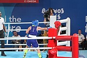 Deutsch: Boxen bei den Olympischen Jugendspielen 2018 Tag 12, 18. Oktober 2018 - Finale Fliegengewicht Mädchen – Martina La Piana (Italien, blau) schlägt Adijat Gbadamosi (Nigeria, rot) 5-0; Ringrichter ist James Beckles (Trinidad und Tobago). English: Boxing at the 2018 Summer Youth Olympics on 18 October 2018 – Girl's flyweight Gold Medal Bout - Martina La Piana (Italy, blue) beats Adijat Gbadamosi (Nigeria, red) 5-0; Referee is James Beckles (Trinidad and Tobago). Español: Boxeo en los Juegos Olímpicos Juveniles de Verano de 2018 en 18 de octubre de 2018 - Combate a medalla de oro de peso mosca para mujeres: Martina La Piana (Italia, azul) le gana a Adijat Gbadamosi (Nigeria, roja) 5-0; El árbitro es James Beckles (Trinidad y Tobago).