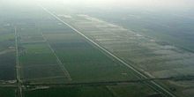 Aerial view of the New (middle diagonal grey line) and Old (right diagonal grey line) Bedford Rivers crossed by the Ely-March railway (bottom dark line)