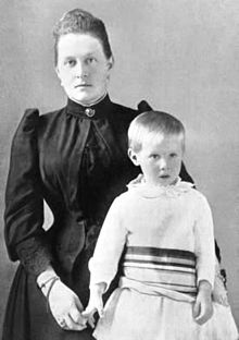 photographie noir et blanc : une femme en robe noire et un enfant