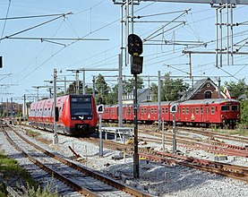 圖中左側列車即為第二次開通期間的哥本哈根市郊鐵路Ex線列車，2006年7月拍攝於海勒魯普站