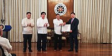 Duterte (2nd from right) leads the awarding of the Certificate of Public Convenience and Necessity to the Mislatel Consortium represented by businessman Dennis Uy (right) on July 8, 2019. Duterte awards Mislatel CPCN.jpg