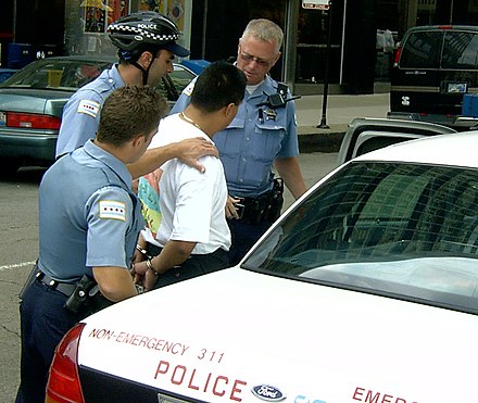 Police officers taking a man into custody in Chicago, United States