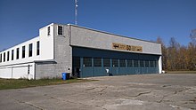 Flughafenhangar hinter rissigem Bürgersteig