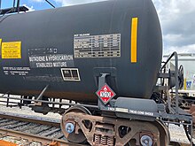 A railway tank car carrying a butadiene and hydrocarbon mixture, displaying hazardous materials information including a diamond-shaped U.S. DOT placard showing a UN number Placard 1010.jpg