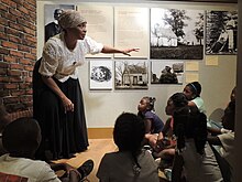 A costumed historian speaking to children at the Reginald F. Lewis Museum Reginald F. Lewis Museum Living History Tour.jpg