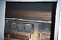 Estrade Intérieur d'un sauna à fumée collectif. La banquette est recouverte d'une bande de tissu pour l'hygiène. Les seaux (recouverts de suie) contiennent l'eau qui sera versée sur le poêle avec la louche à long manche.  