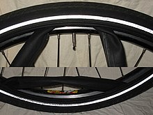 A tubed, clincher tire showing the inner tube protruding between the tire and the rim Schlauch herausziehen.jpg