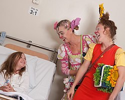 Ett barn får besök av två sjukhusclowner.