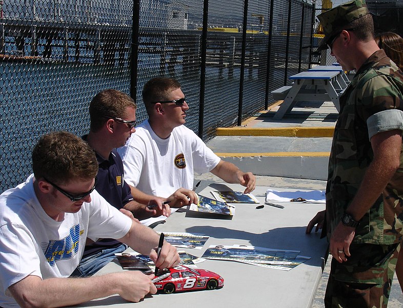 File:US Navy 060419-N-6552M-001 NASCAR racers Dale Earnhardt Jr., Shane Huffman, and Mark McFarland (seated left to right), autograph photos and memorabilia for Special Warfare Combatant-craft Crewmen.jpg