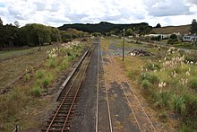 View of the former Waiotira railway station in 2010. This was once an important intermediate station with substantial facilities and an island platform with tracks on the left as well as the right. Passengers transferred here between the Northland Express/railcars and mixed trains to Dargaville. Waiotira overview.jpg