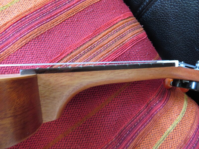 File:17 inch pocket ukulele branded "ultnice", detail view of neck (side) with frets and strings.jpg