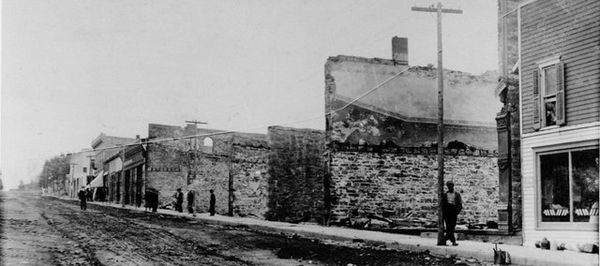 Citizens wander Oak Street, looking at the burned out buildings after the October 1908 fire