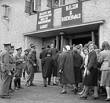 Reeducation: Inhabitants of Burgsteinfurt on their way to a cinema in which, on 30 May 1945, recordings of the aftermath of the liberation of the Bergen-Belsen and Buchenwald concentration camps were shown. British military police and German police officers stand next to the cinema's entrance. BU 007016.jpeg