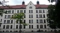 School with gymnasium, attached caretaker's apartment, front garden, school yard and enclosure wall with portal