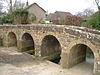 Stone bridge with four arches and low parapet.