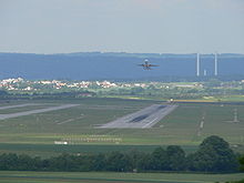 Blick auf die bestehende Start- und Landebahn. Im Hintergrund die Schornsteine des Heizkraftwerk Altbach/Deizisau