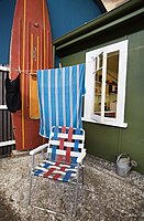 A folding chair and a surfboard outside a beach house from the fifties ('50s house or 50's house) Auckland, New Zealand