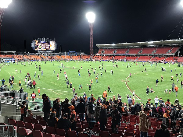 Patrons play on the surface of the stadium after an AFL game